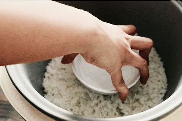 Cho bát nước trắng vào nồi cơm để chữa cơm bị khê.